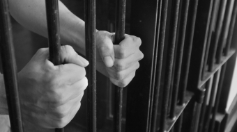 Prison Cell Bars.Hand of the prisoner holding steel lattice jail bars.Criminal justice imprisonment concept.